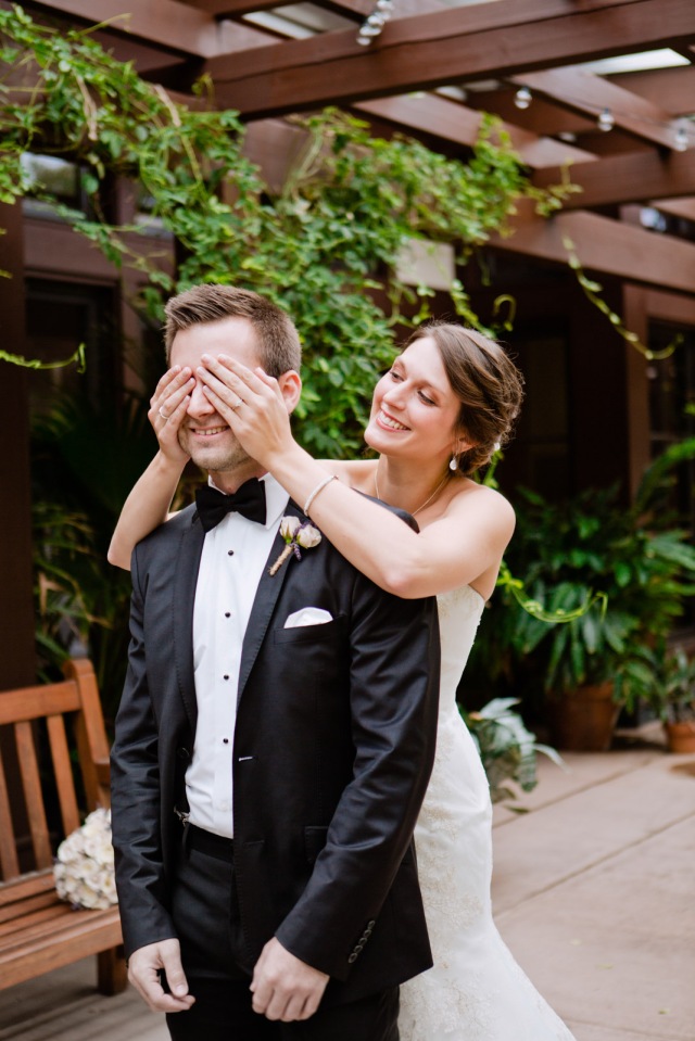 a bride covers her grooms eyes before he sets eyes on her for the first look