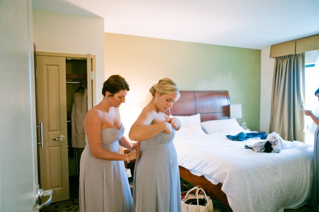 bridesmaid help one another to get ready for a wedding day